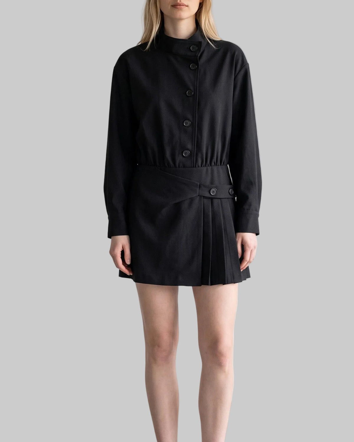 Model wearing the Celeste black belted shirt mini dress with long sleeves, button-front detailing, and a pleated mini skirt.