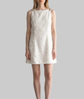Model wearing the Lucia ivory jacquard mini dress with textured floral fabric and gold-tone shoulder details