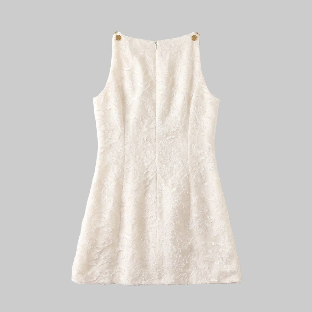 Model wearing the Lucia ivory jacquard mini dress with textured floral fabric and gold-tone shoulder details