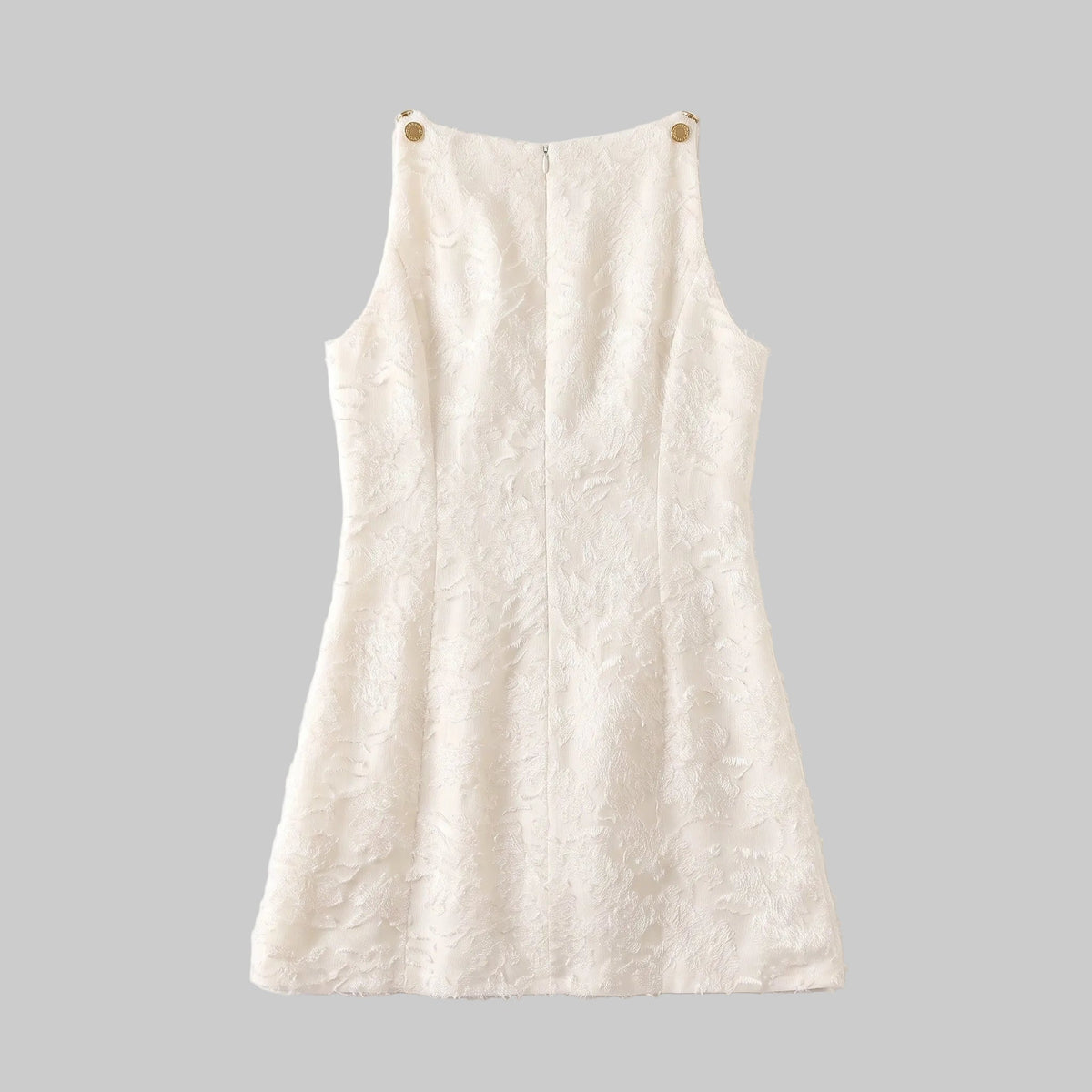 Model wearing the Lucia ivory jacquard mini dress with textured floral fabric and gold-tone shoulder details