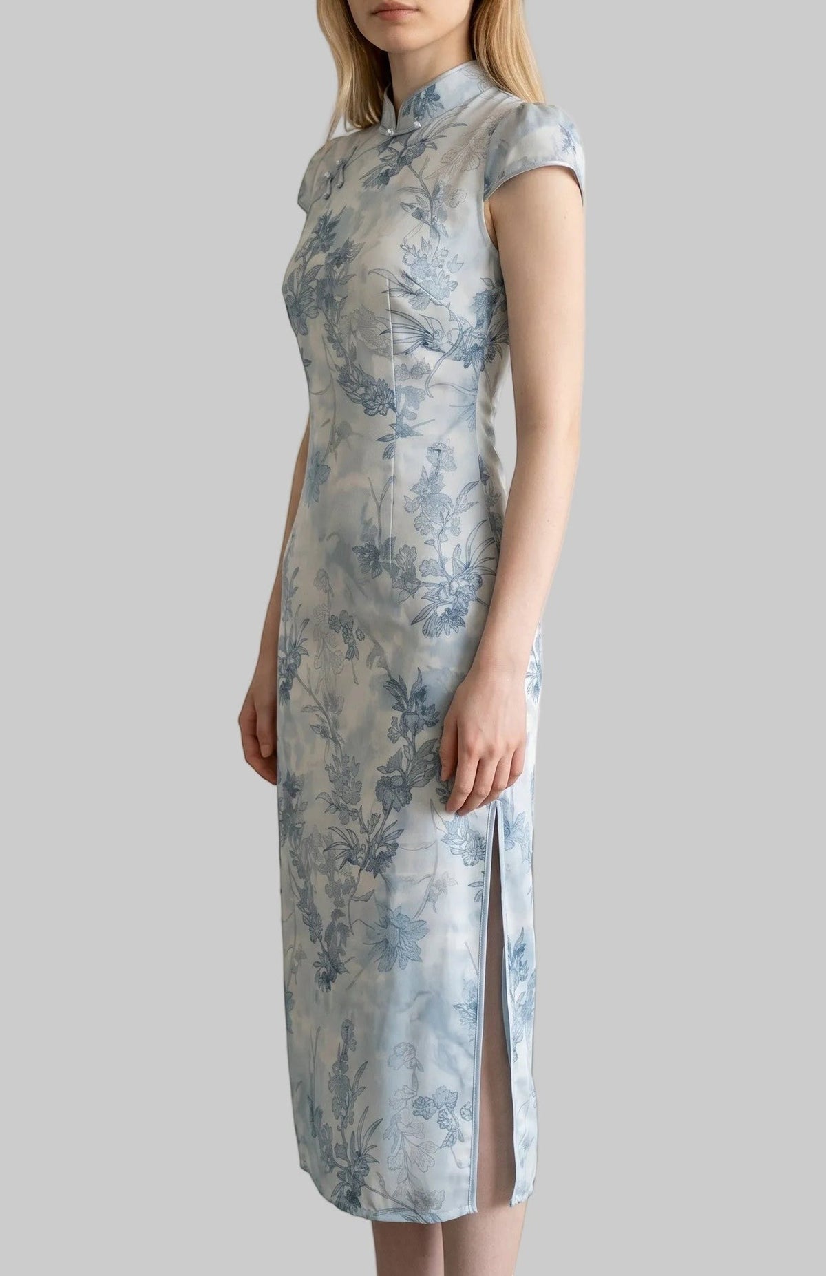 LUNRIA blue floral cheongsam midi dress featuring a traditional Mandarin collar, cap sleeves, frog-button details, and a fitted silhouette.