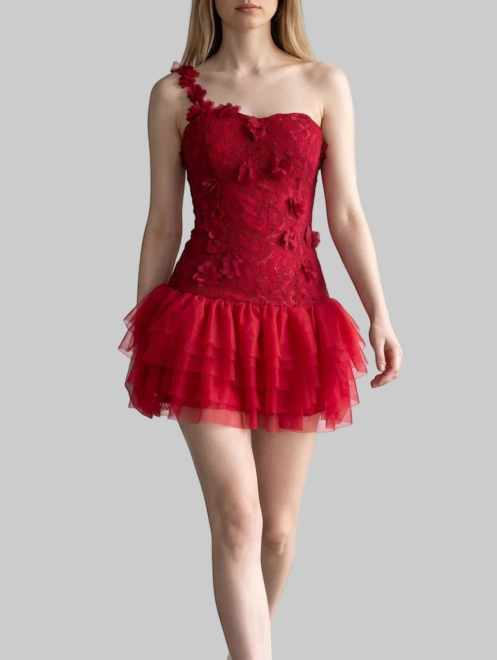 Red one-shoulder corset mini dress with 3D rose appliqués, floral lace, and layered mesh ruffle skirt.
