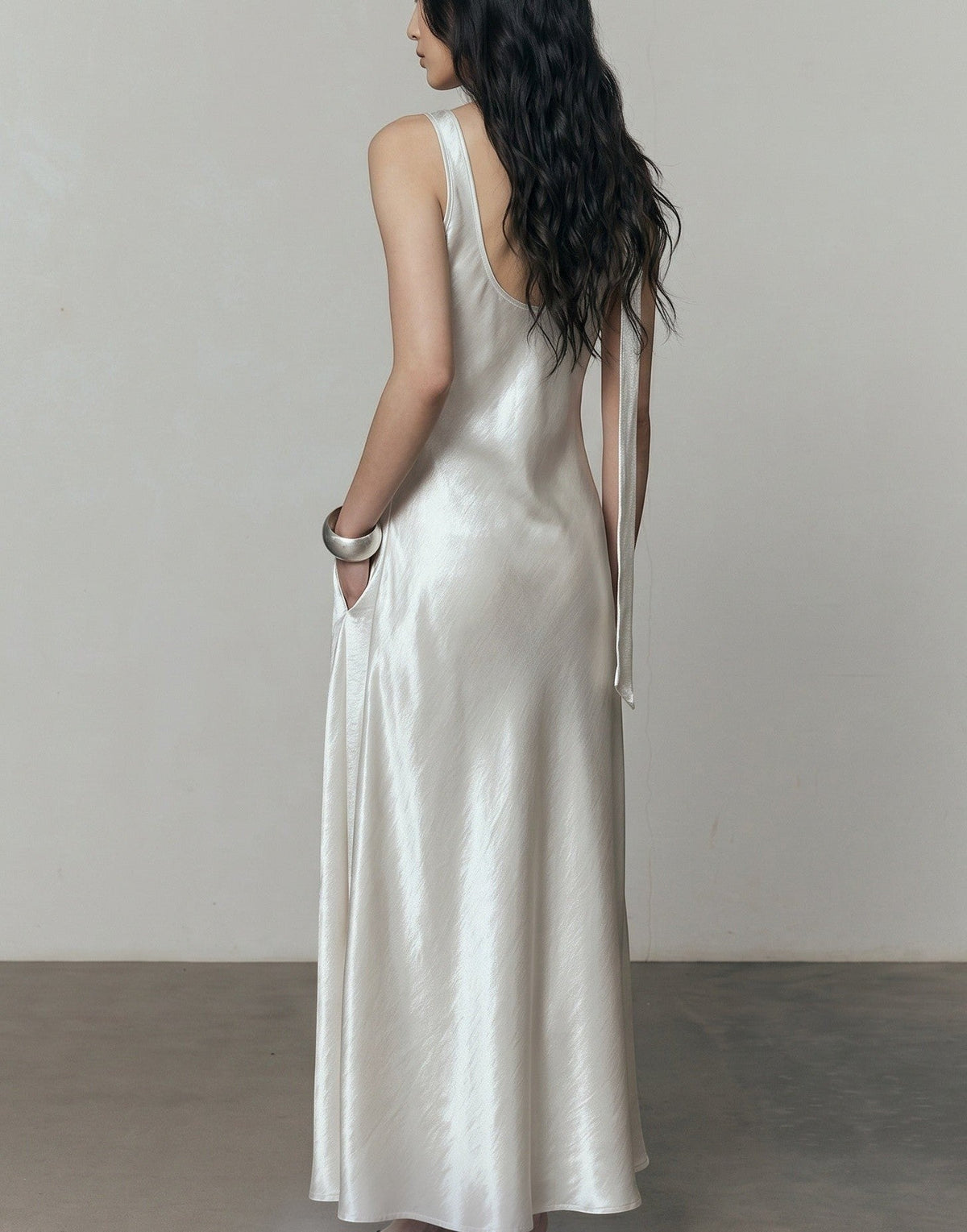 LUNRIA pearl white satin maxi dress featuring a backless silhouette, V-neckline, flowing floor-length skirt, and matching neck scarf.