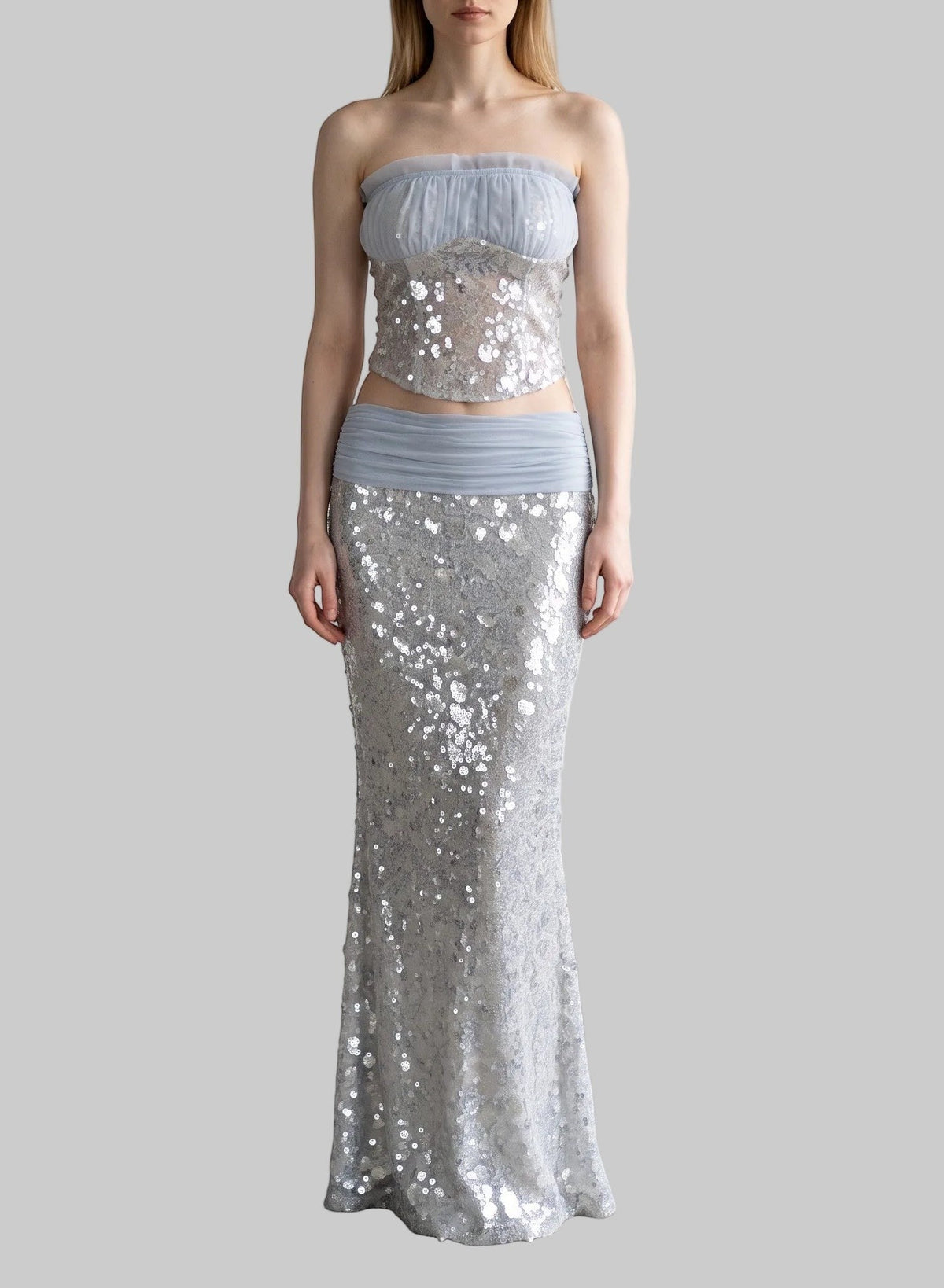 LUNRIA silver sequin two-piece set featuring a strapless corset top with sheer blue trim and a matching high-waisted sequin maxi skirt.