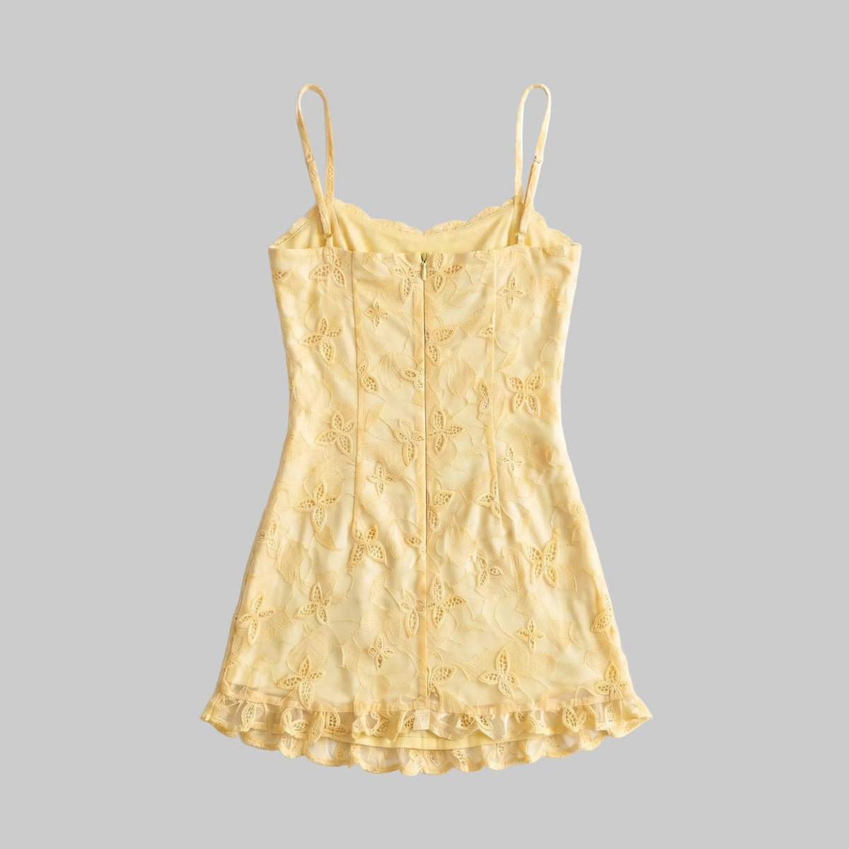 LUNRIA yellow lace mini dress featuring spaghetti straps, contrast pink trim, a fitted silhouette, ruffle hem, and front graphic detail.